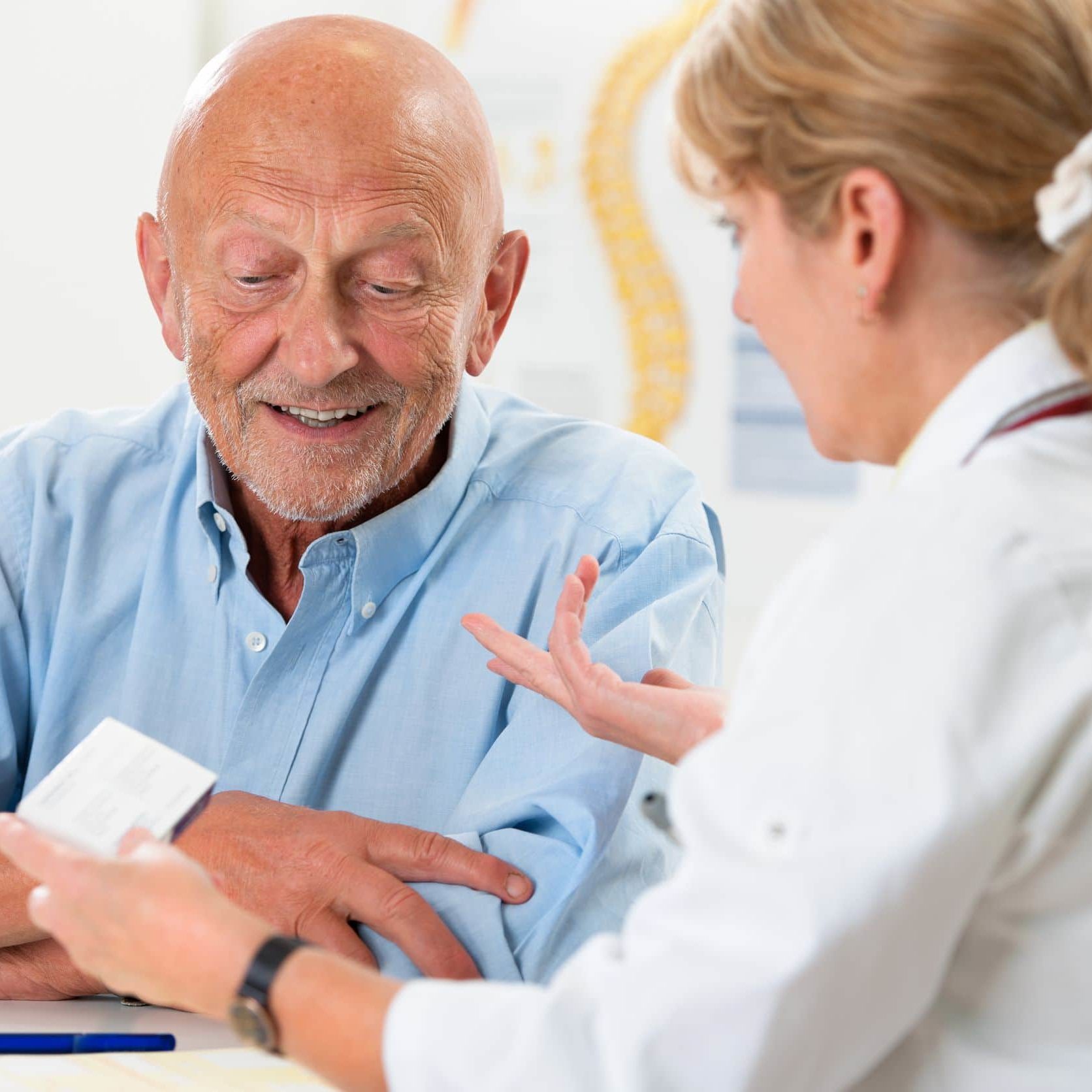 doctor talking to her male senior patient at office Parkinson's disease treatment